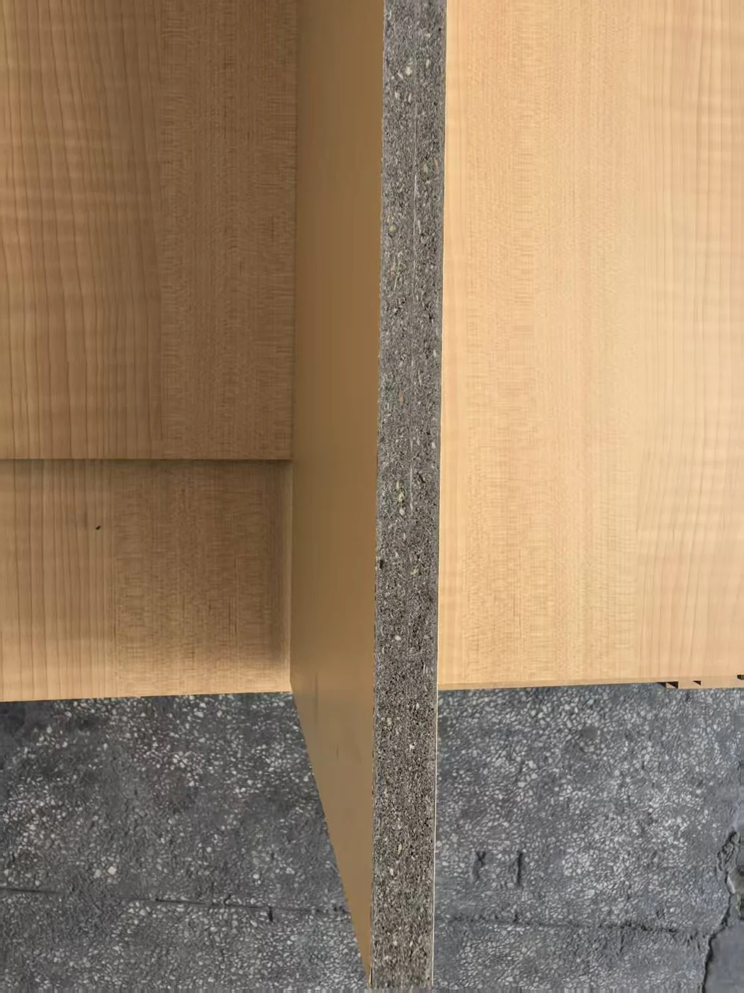 Close view of dark acoustic backing at a grooved panel edge