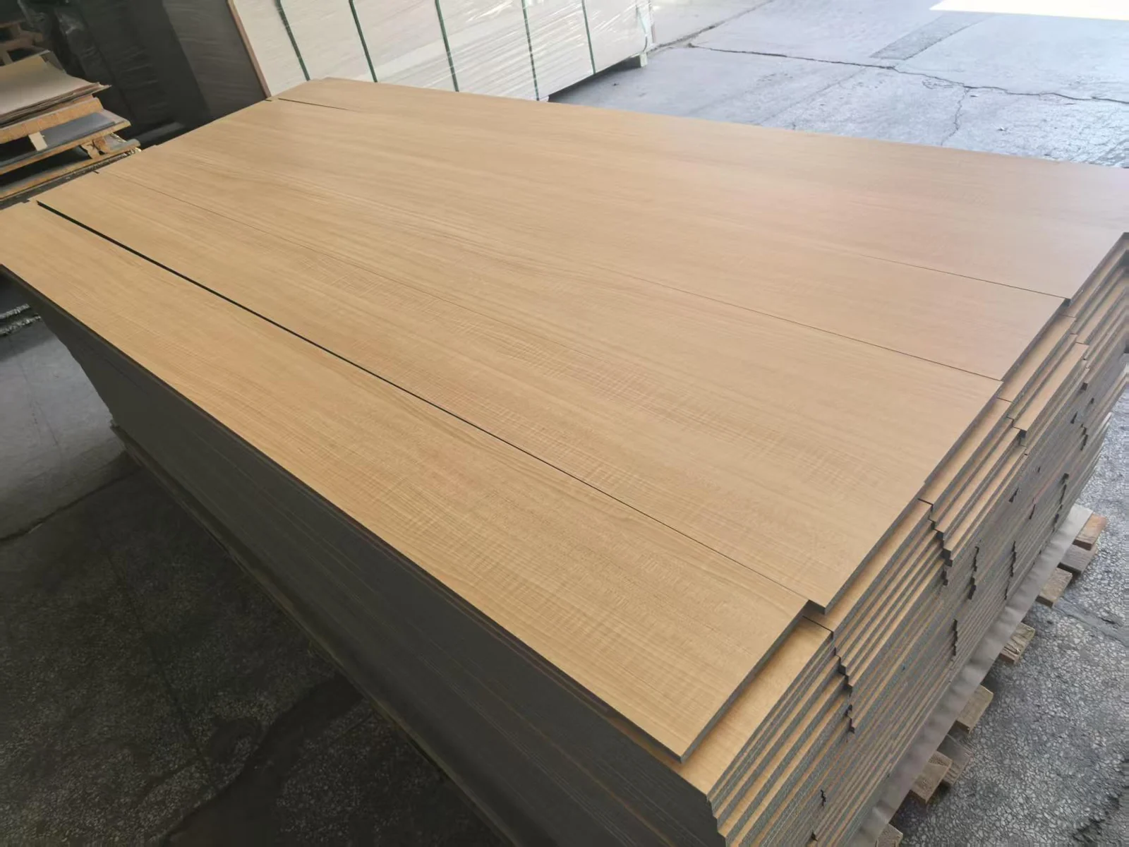 Stack of wood finish grooved acoustic panels in the workshop