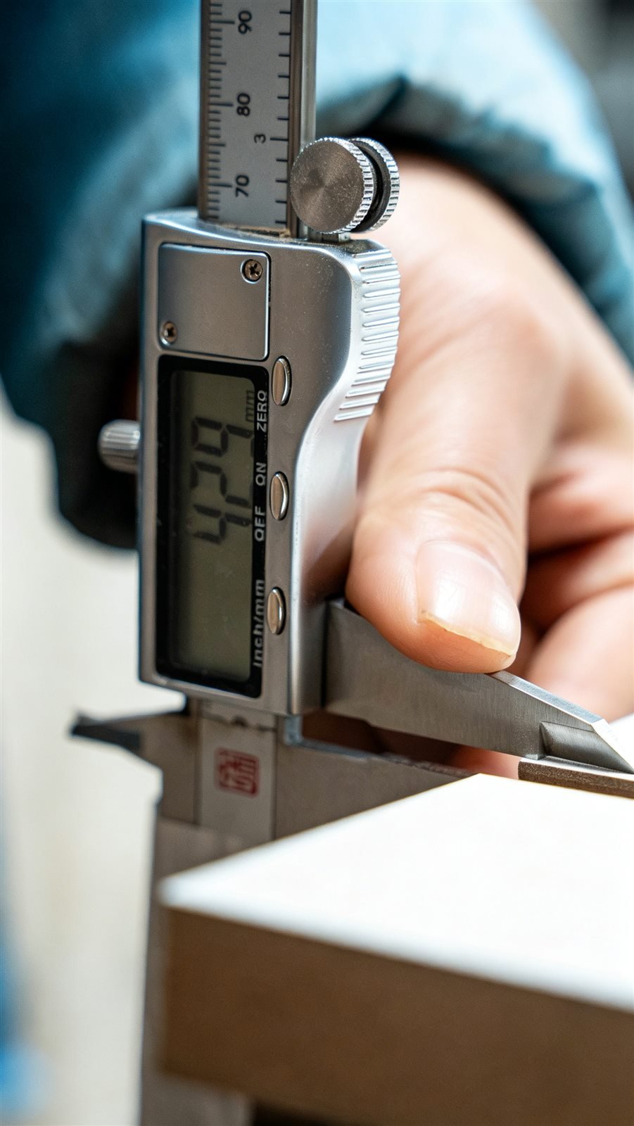Operator checking the dimensions of an MDF slatwall batch